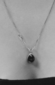 A beautiful necklace and pendant being worn with an ugly crab claw clasp about an inch from the pendant.